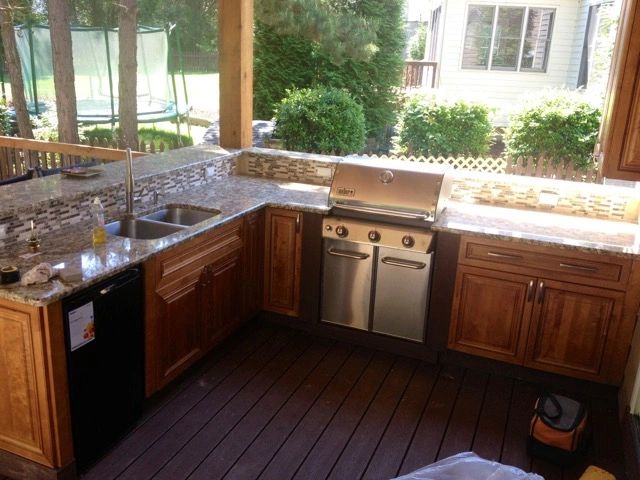 Outdoor kitchen on covered patio with stainless steel grill